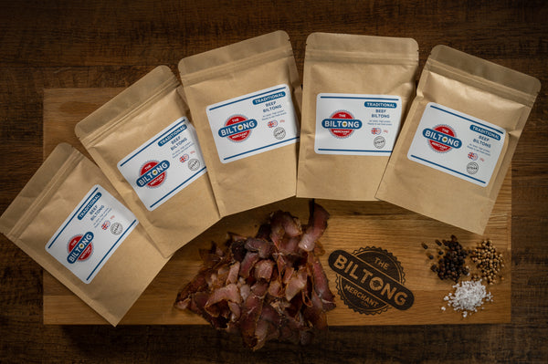 The Biltong Merchant Snack Packs of Traditional Biltong on a wooden board with biltong and spices