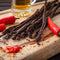 Chilli Beer Sticks Stokkies on a cutting board with chillies and beer, from Simply African Food for The Biltong Merchant