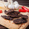 Chilli Beef Biltong Chips Crisps with garlic bulb & chillies on wood, from Simply African Food for The Biltong Merchant