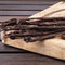 Traditional beef Beer Sticks Stokkies biltong on a wooden cutting board from Simply African Food for The Biltong Merchant